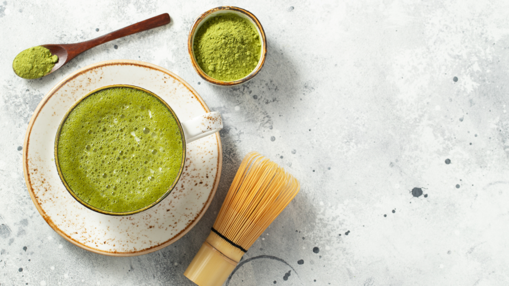 Matcha tea with a bowl of powder, a wooden spoon and a special whisk